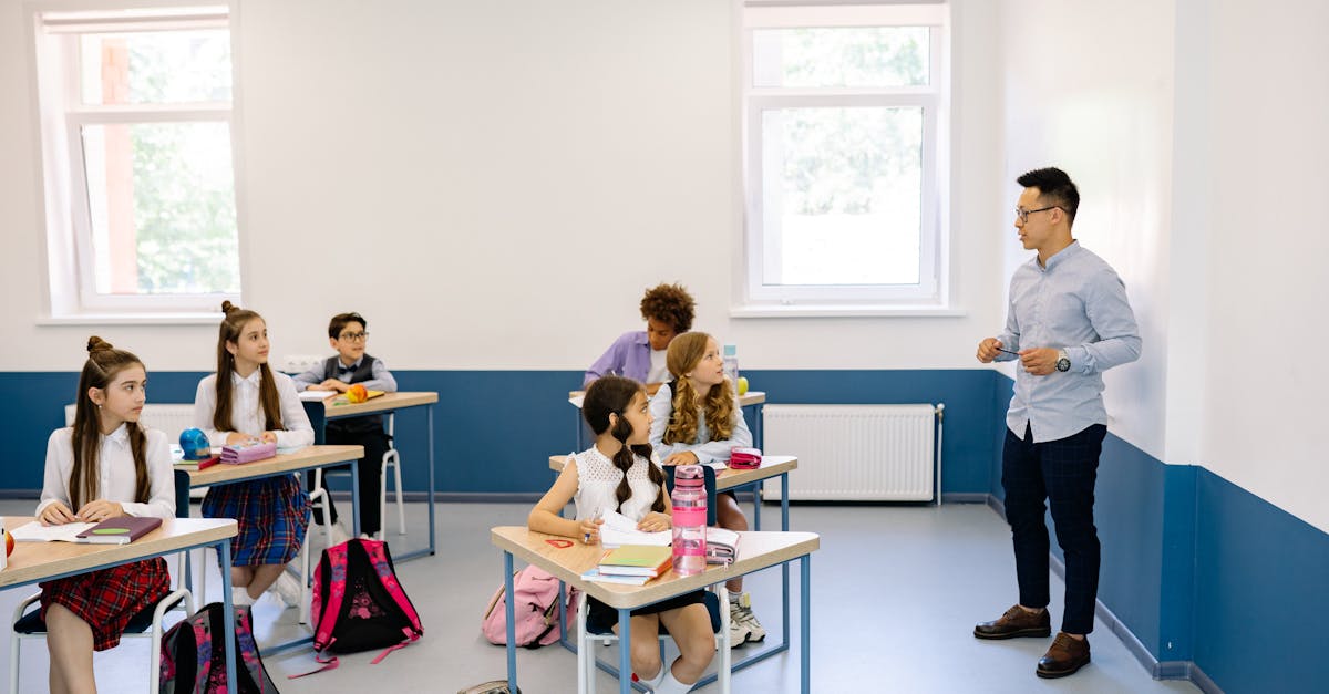 Students attentively listening to a teacher during a classroom lesson.